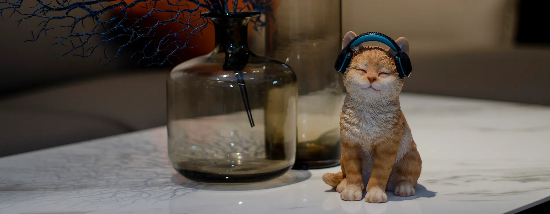 Figurine of a cat wearing headphones with its eyes closed